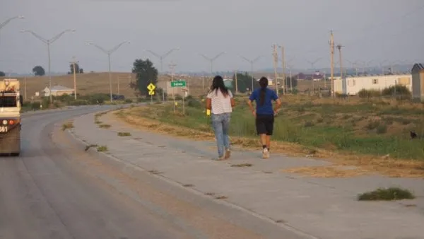 Oglala_two_walking_to_town_16x9 two people walking toward town